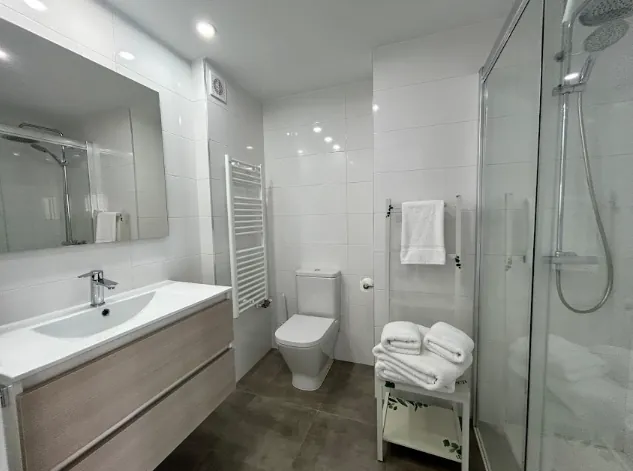 Baño con mueble de lavabo, inodoro y ducha