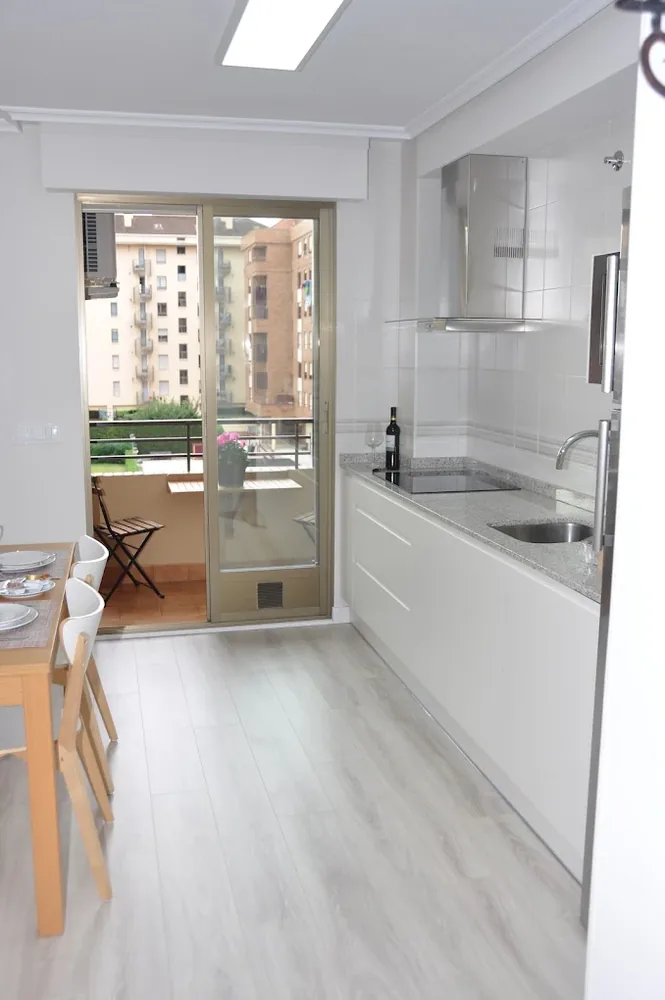 Cocina blanca equipada con salida a la terraza
