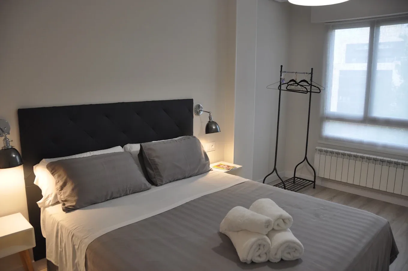 Dormitorio con toallas preparadas y burro para la ropa